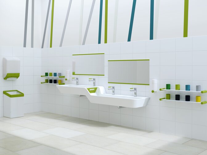 Plan de toilette adapté aux enfants avec des accents verts, lavabo avec graduation en hauteur et en profondeur intégrée à côté de barres de gobelets à dents colorées