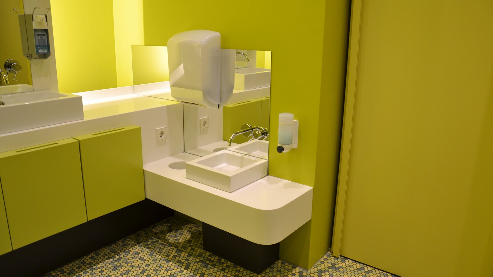 Bathroom equipped with paper towel dispenser, soap dispenser and mirror