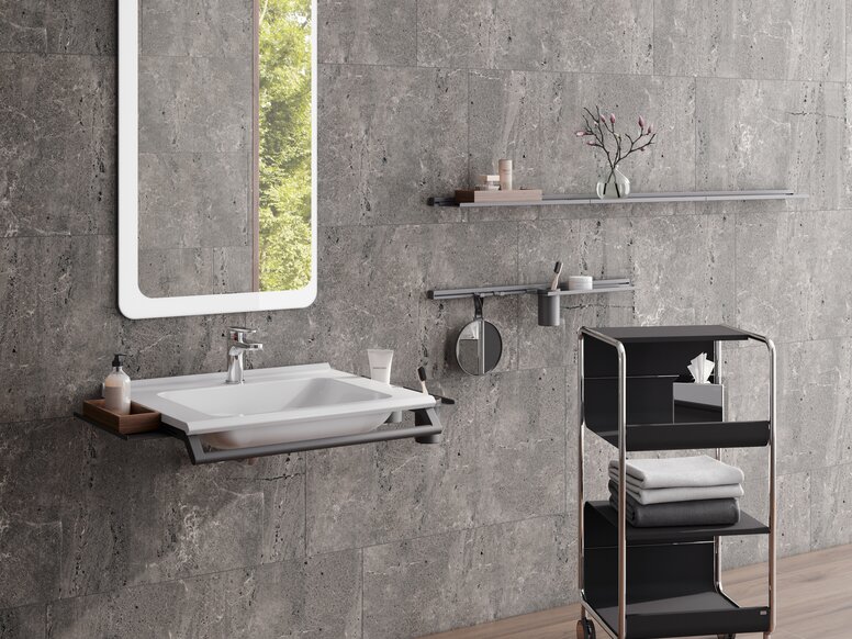 Modular washbasin with grab rail and shelves, side trolley next to it in matt black