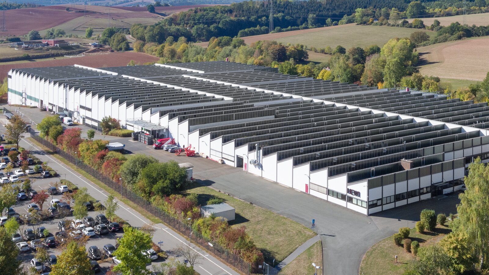 Dronebeeld van de HEWI-fabriek met witte gevel